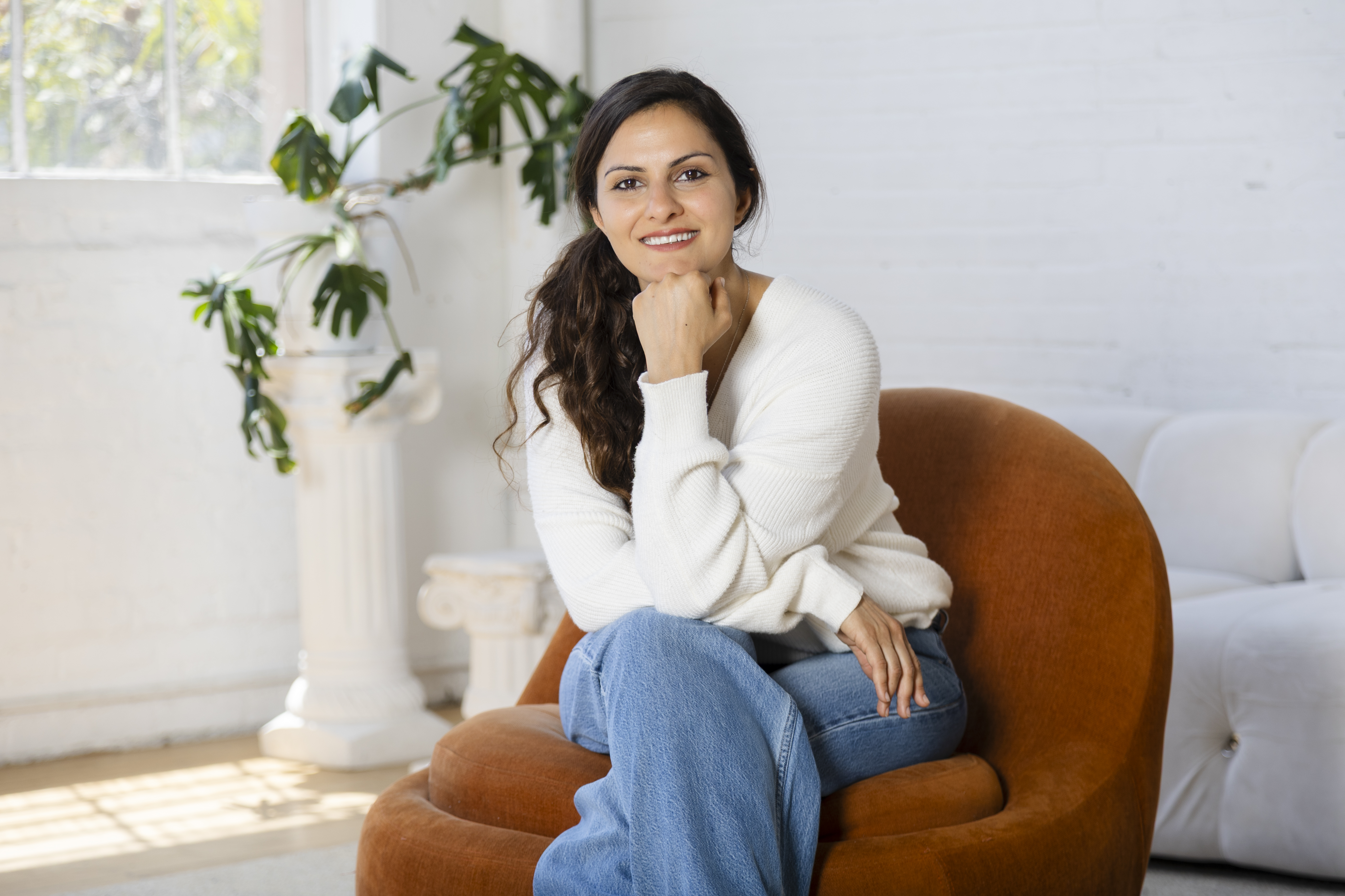 Elena Gharibian seated in a bright, welcoming therapy space